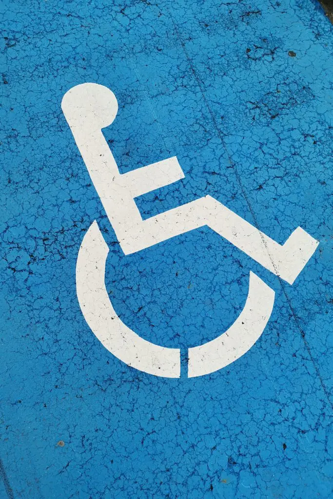 A white handicap parking symbol on a blue background