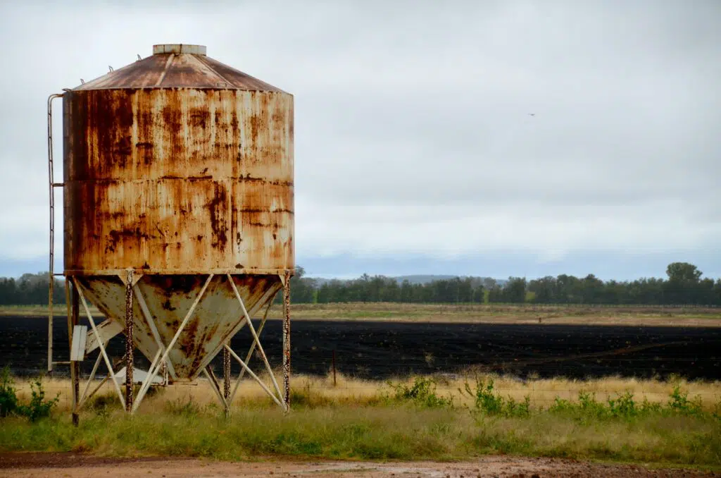 An old rusted silo alone in a field