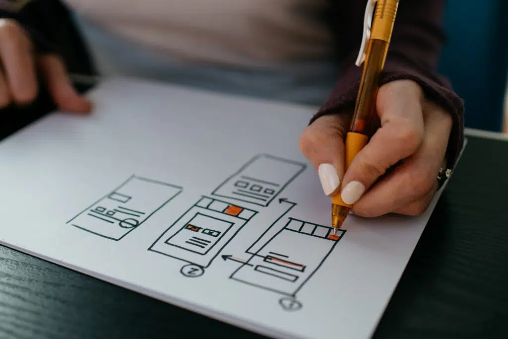 A woman sketching wireframes of a mobile website or app